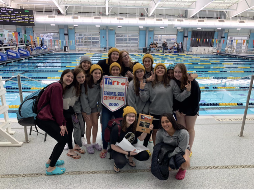 The swim team holding their plate and banner of 1st place. Photo courtesy of the author.