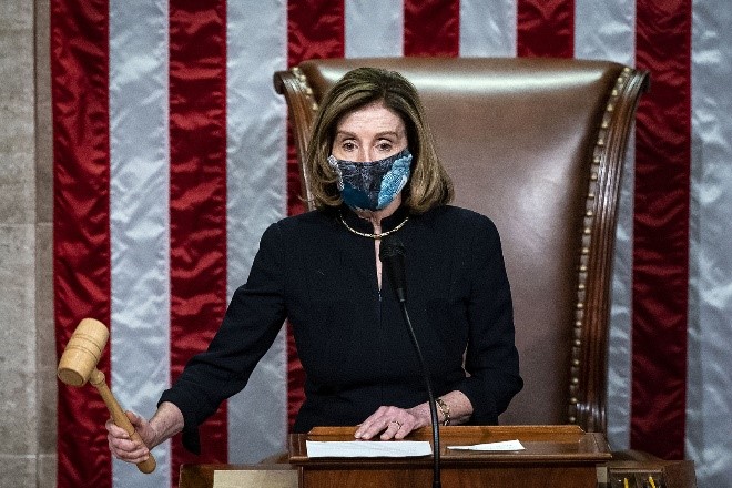 House Speaker Nancy Pelosi bangs her gavel to signify the passing of the impeachment articles, now heading to the Senate. She wore the same outfit as the first impeachment in 2019.