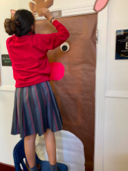 Junior homeroom representative, Marianna Benavides, decorating her homeroom door. The door was decorated as a reindeer with a scarf. 