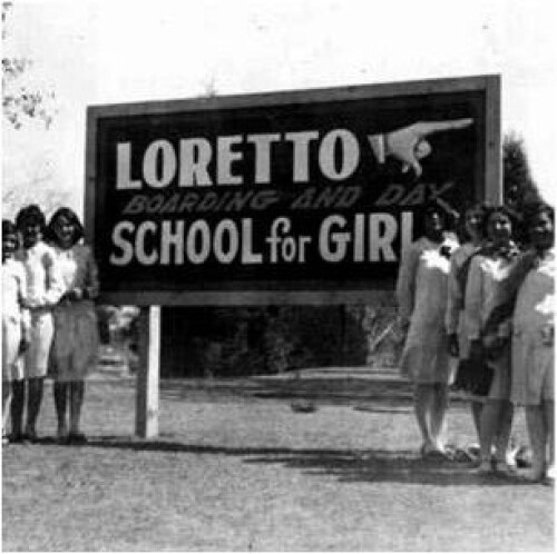 Girls stand next to a sign pointing to the newly built Loretto Academy in 1923. The academy was originally for both boarding students and day students. Photo courtesy of Loretto Academy