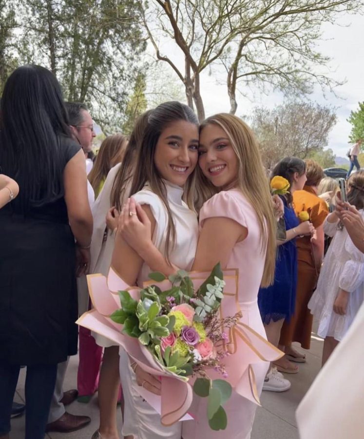 Senior Carolina Fernandez (pictured left) and Junior Maria Fuentes (pictured right) are paired together to participate in Ring Rose. Each pair celebrated afterwards and took photos in front of the gym. Photo courtesy of Maria Fuentes
