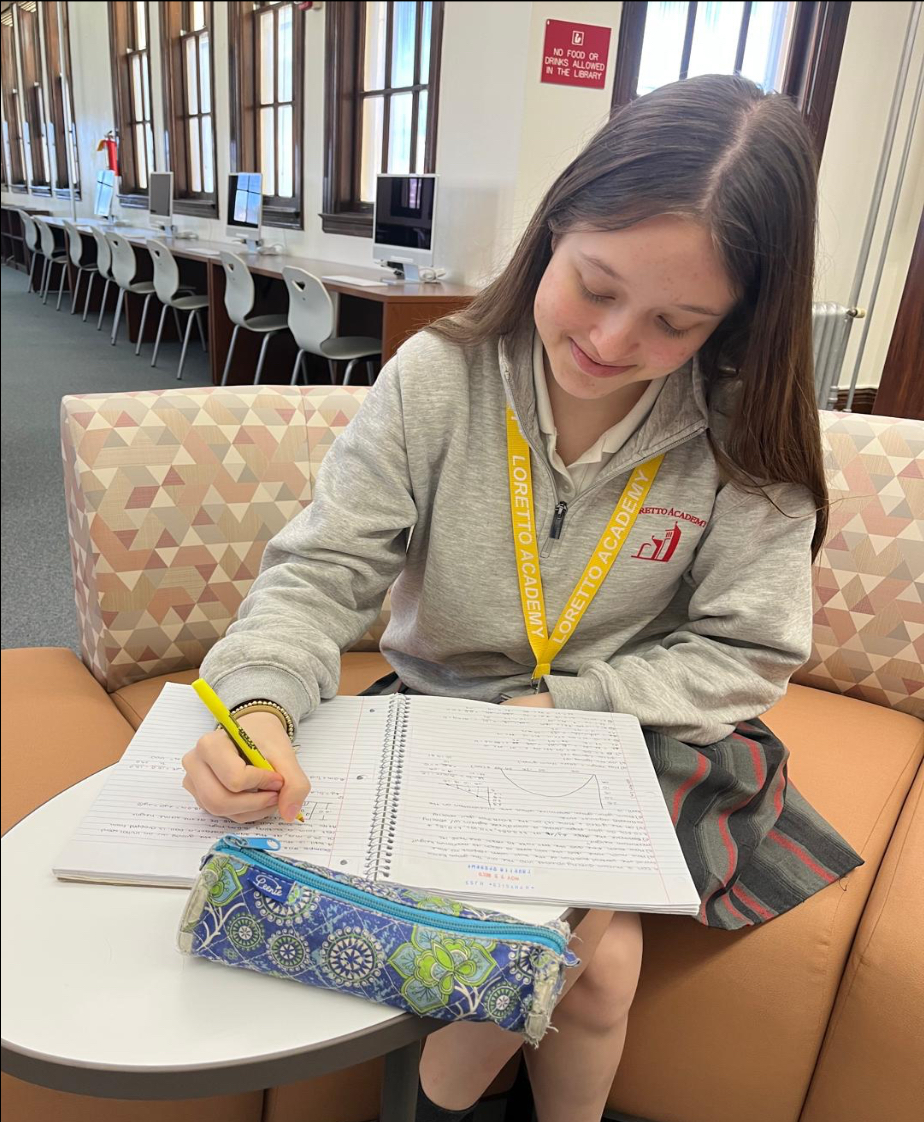 Loretto Academy senior, studying for the physics final in the library. She is using highlighters to facilitate her studying.