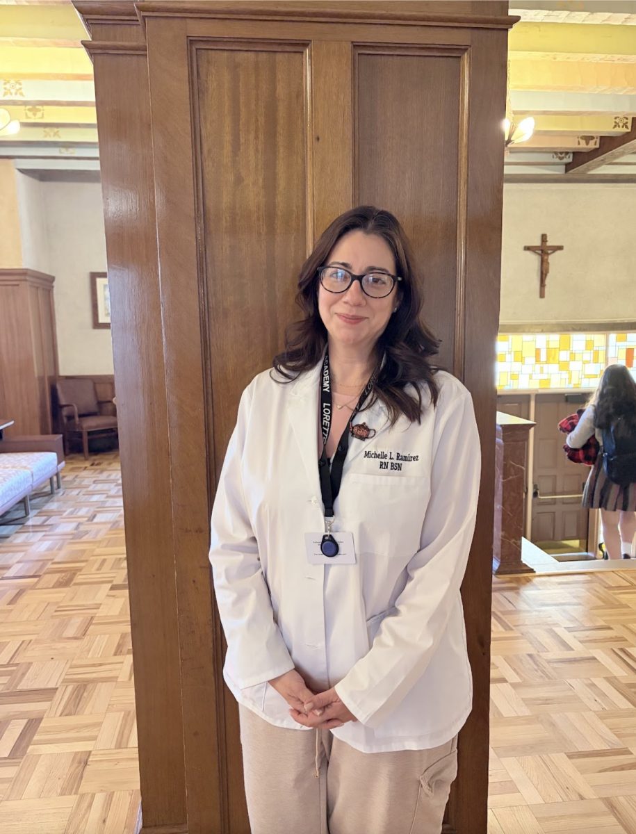 Ms. Michelle Ramirez is pictured with her nurse white coat. She is standing in the foyer of the front of the school. Photo courtesy of Viviana Liano