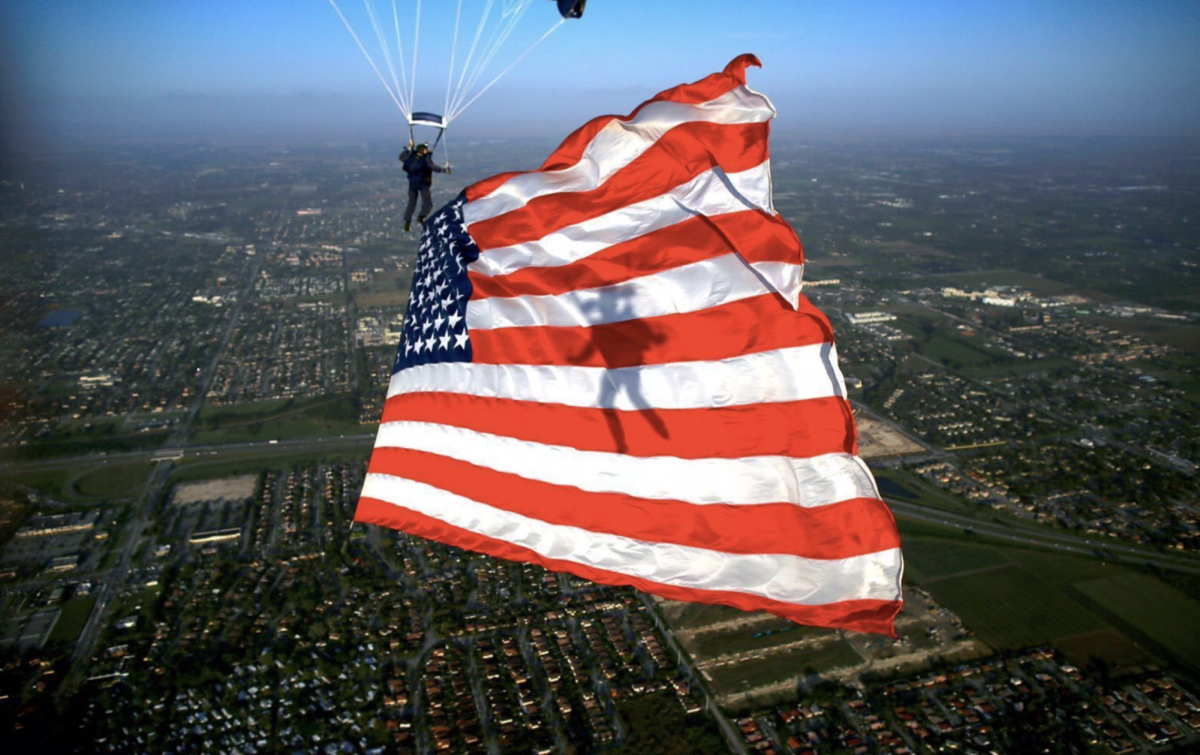 US Navy parachute team presenting the American flag during training. The flag waves in the wind, standing as a symbol of national unity for US soldiers preparing for battle. Photo courtesy of Flickr.