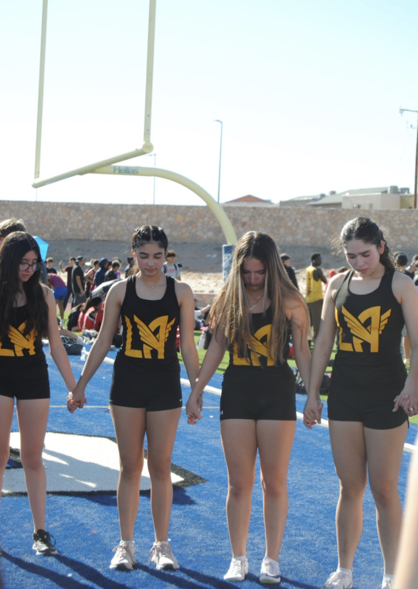 Loretto Angels say a prayer before taking their places on the track. Head Coach Joe inspires the girls to say a prayer before each meet. Photo courtesy of Sofia Castillo (@sofies-flicksla).